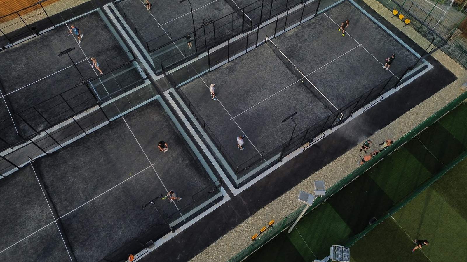 Floodlit Pukka Padel courts at dusk.