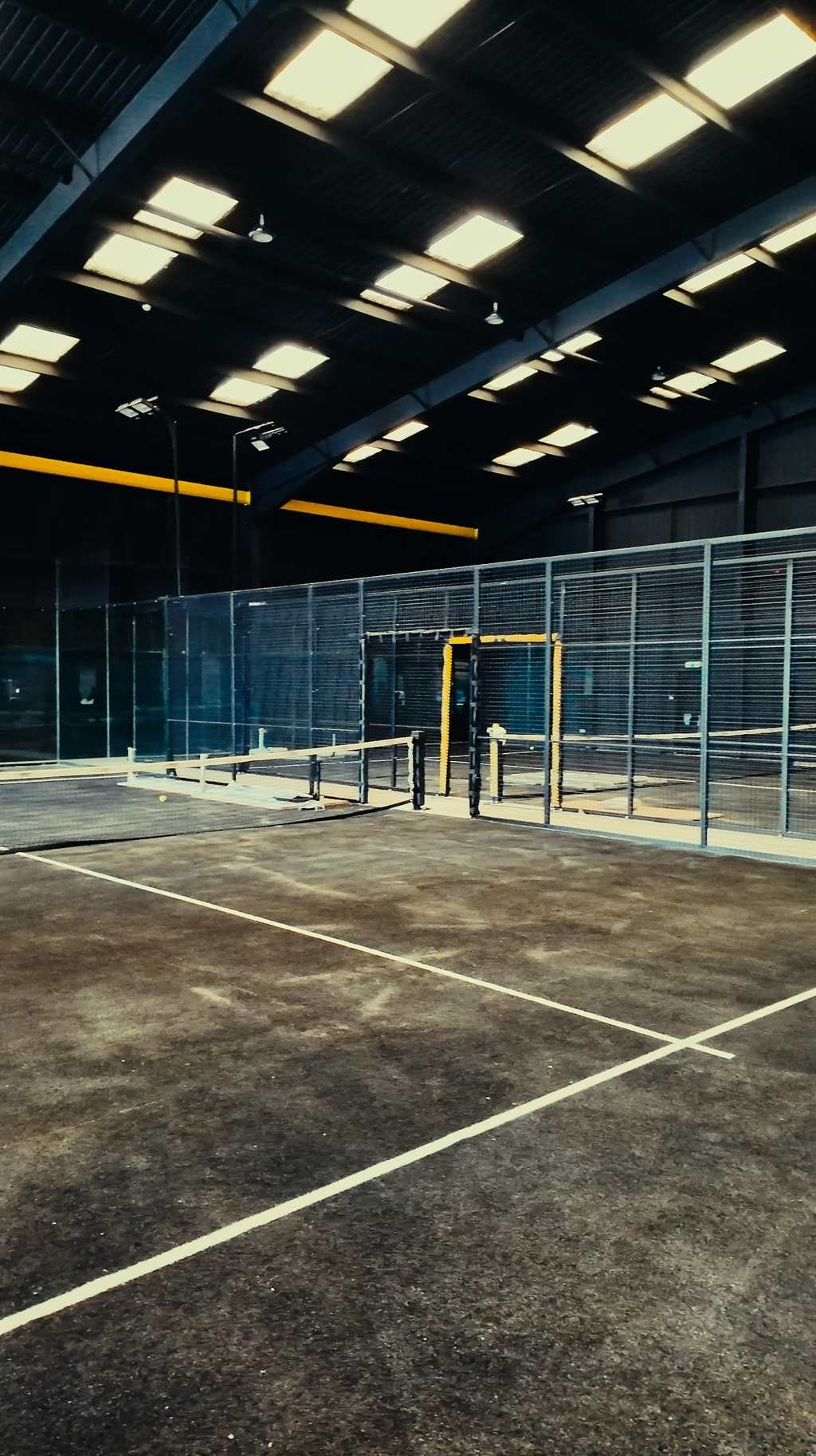 The glass back wall of an indoor court at Pukka Padel Kidderminster.